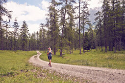 Frau beim Wandern auf Waldweg