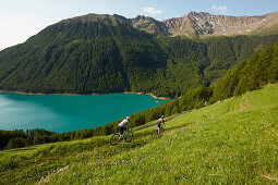 Couple with mountainbike riding down a track