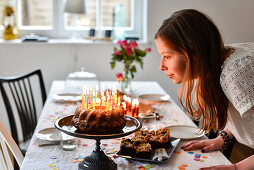 Mädchen pustet Kerzen auf Geburtstagskuchen bei Teenager Geburtstag von 14 jährigem Mädchen in Hamburg, Deutschland