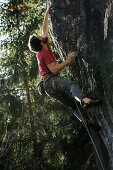 Young man climbing at a rock face, Schwaerzer Wand, Bavaria, Germany