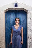 Junge Frau steht vor einer blauen Tür, Sao Tome, Sao Tome und Príncipe, Afrika