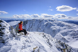 Woman sitting at summit of Falkert, Falkert, Nock Mountains, Biosphaerenpark Nockberge, Carinthia, Austria