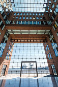 The inner courtyard of the office house Elbflorenz in Grosse Elbstrasse in the old timber harbour with view at container cranes, Hamburg, Germany