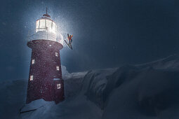 Young male skier jumping at a lighthouse in the deep snow, Andermatt, Uri, Switzerland