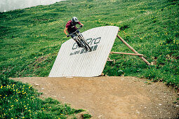 Bikepark Brandnertal, Mountainbiker, Downhill, Sprung, Mountainbike, Wald, Wiese, Vorarlberg, Österreich, Berge, Alpen