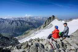 Man and woman sitting at summit of Reichenspitze, Reichenspitze, Zillergrund, Reichenspitze group, Zillertal Alps, Tyrol, Austria