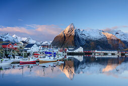 Meeresbucht mit Booten und Häusern von Hamnoy, verschneite Berge im Hintergrund, Hamnoy, Lofoten, Norland, Norwegen