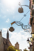 Historical signs and the church Franziskanerkirche in the Herrengasse, Rothenburg ob der Tauber, Bavaria, Germany