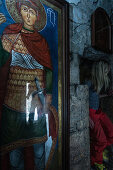 Young woman in a small church next to a image of a saint, Gudauri, Mtskheta-Mtianeti, Georgia