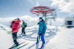 Drei junge Skifahrer steigen aus einem Sessellift aus, Gudauri, Mzcheta-Mtianeti, Georgien