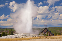 Old Faithful Geyser and Old Faithful Lodge at Upper Geyser Basin , Yellowstone National Park , Wyoming , U.S.A. , America