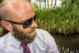 Mann mit bart und Sonnenbrille beim Paddeln, Spreewald, Spree, Familienausflug, Familienfeier, Kajak, Urlaub, Sommer, Ferien, Oberspreewald, Brandenburg, Deutschland