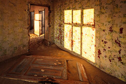 The morning sun in a house of ghost town Kolmanskop, Karas, Namibia