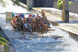 People on a traditional wooden raft on a shute in Thalkirchen, Munich, Upper Bavaria, Bavaria, Germany