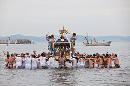 Omikoshi portable shrine carried into sea during Seijin-Sai-Festival at Enoshima beach, Fujisawa, Kanagawa Prefecture, Japan