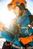 Young male skier hiking through the deep powder snow in the backcountry, Kaprun, Salzburg, Austria