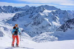 Woman backcountry skiing ascending towards Breiter Grieskogel, Stubai Alps with Schrankogel in background, Breiter Grieskogel, Stubai Alps, Tyrol, Austria