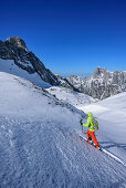 Frau auf Skitour steigt zur Hochfeldscharte auf, Reiteralm im Hintergrund, Sittersbachtal, Hochfeldscharte, Nationalpark Berchtesgaden, Berchtesgadener Alpen, Oberbayern, Bayern, Deutschland