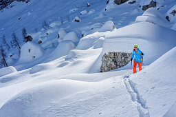 Woman backcountry skiing ascending through boulders towards Sella Nabois, Sella Nabois, Julian Alps, Friaul, Italy