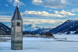 Clocktower of Reschen in ice-covered lake Reschensee, Ortler in background, lake Reschensee, Vinschgau, South Tyrol, Italy