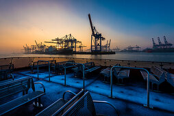 Sunrise on a winter's day in the Hamburg port at the container terminal Burchardkai seen from the Elbe ferry, Hamburg, Germany