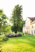 Garden party, guests having dinner at long table, event dinner at the caste Lühburg, Mecklenburg lakes, Mecklenburg lake district, Lühburg, Mecklenburg-West Pomerania, Germany, Europe