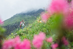 Young woman hiking up to the Kemptener Hütte in the Alps