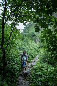 Young woman hiking up to the Kemptener Hütte in the Alps