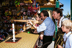 Familie in Tracht am Schießstand im Oktoberfest, München, Bayern, Deutschland