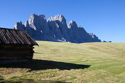 Small wooden hay cabin in front of the Geisler peaks, Dolomites, South Tirol, Italy