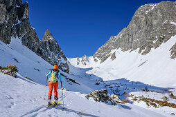 Woman backcountry skiing ascending through Hoellkar, Weisseck in background, Hoellkar, Felskarspitze, Radstadt Tauern, Carinthia, Austria