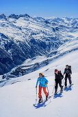 Three persons backcountry skiing ascending towards Grundschartner, Grundschartner, Zillertal Alps, Tyrol, Austria