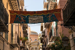 Kunstvolles Banner zwischen zwei Balkonen in der Gasse zum Theater Massimo, Via Bara All'Olivella, Teatro Massimo Vittorio Emanuele, Palermo, Sizilien, Italien, Europa