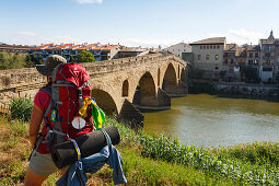 Pilgerin, Puente la Reina, Brücke, 11.Jhd., Rio Arga, Fluss, Camino Frances, Jakobsweg, Camino de Santiago, Pilgerweg, UNESCO Welterbe, europäischer Kulturweg, Provinz Navarra, Nordspanien, Spanien, Europa