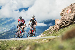 Two young people on their racing cycles in the Kitzbühler Alps, Kitzbühlerhorn, Tyrol, Austria