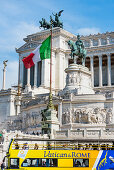 The monument Monumento a Vittorio Emanuele II with national flag and tourist coach, Rome, Latium, Italy