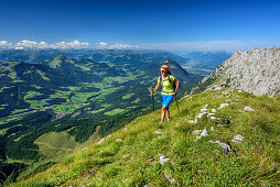 Woman hiking ascending towards Sonneck, Soellland and valley of Inntal in background, Sonneck, Kaiser range, Tyrol, Austria