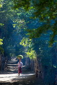 Woman carries basket of leaves on head, Yandabo, near Myingyan, Mandalay, Myanmar