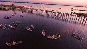 Luftaufnahme von Touristen auf der U-Bein-Brücke und in Ruderbooten auf dem Taungthaman See bei Sonnenuntergang, Amarapura, Mandalay, Myanmar