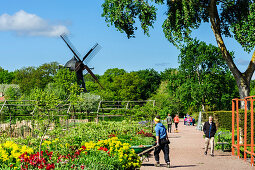 Windmühle im Königspark  Kungsparken mit Blumen und Frau mit Schubkarre, Malmö, Südschweden, Schweden