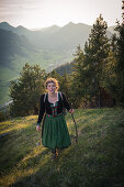 Junge Frau in Tracht wandert auf dem Falkenstein im Allgäu, Pfronten, Bayern, Deutschland