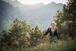 Junge Frau in Tracht wandert auf dem Falkenstein im Allgäu, Pfronten, Bayern, Deutschland