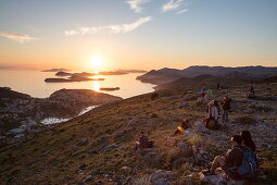 Menschen genießen Aussicht über die Lapad-Halbinsel und vorgelagerte Inseln, vom Hügel nahe der Bergstatation der Dubrovnik-Gondel bei Sonnenuntergang aus gesehen, Dubrovnik, Dubrovnik-Neretva, Kroatien, Europa