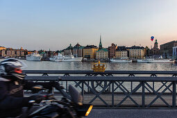 Motorcycle on the Skeppsholmsbron with crown on the railing on the old town, Stockholm, Sweden