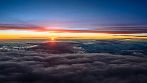 Luftaufnahme knapp über der Wolkendecke bei Sonnenuntergang, Südalpen, Italien