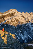 Woman sitting on rock and looking towards Mount Sefton and Footstool, from Mueller Hut, Hooker Valley, Mount Cook National Park, UNESCO Welterbe Te Wahipounamu, Lake Pukaki, Canterbury, South island, New Zealand