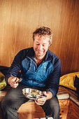 man eating in a cabin, greenland, arctic.