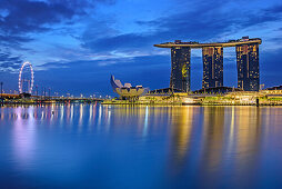 Beleuchtete Skyline von Singapur mit Singapore Flyer, Marina Bay Sands und ArtScience Museum spiegelt sich in Marina Bay, Singapur