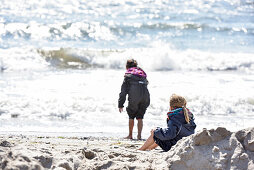 Kinder spielen am Strand im Winter an der Ostsee, Kellenhusen, Schleswig Holstein, Deutschland