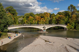 Herbstsimmung am Kabelsteg an der Isar, Besucher geniessen die Nachmittagssonne auf den Kiesbänken und der Brücke, München, Oberbayern, Deutschland